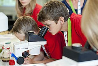 Kind blickt in Mikroskop